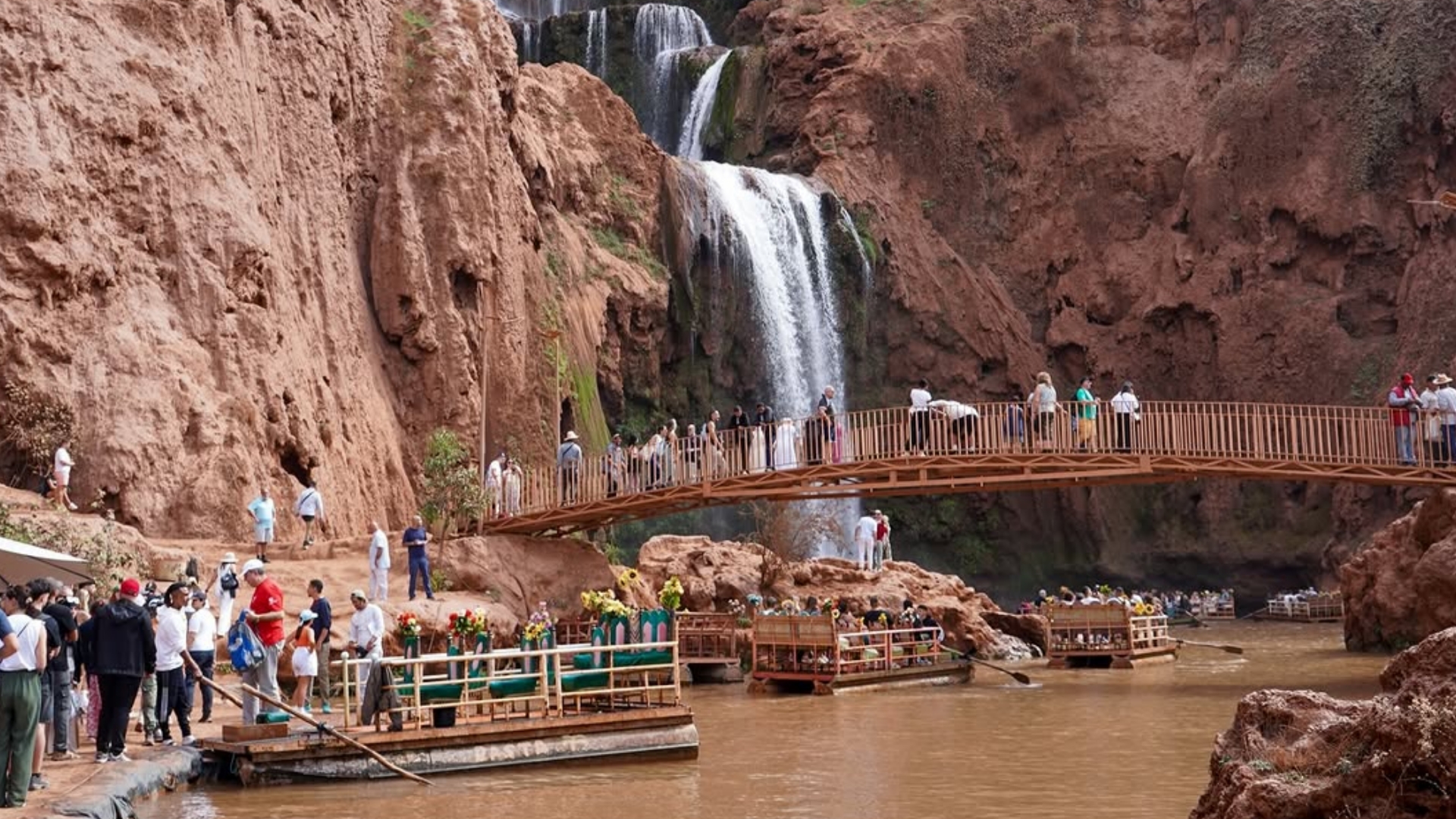 Impresionantes cascadas de Ouzoud con agua cayendo entre acantilados rocosos y un arcoíris al fondo. Reserva tus excursiones desde Marrakech con Haya Viajes.