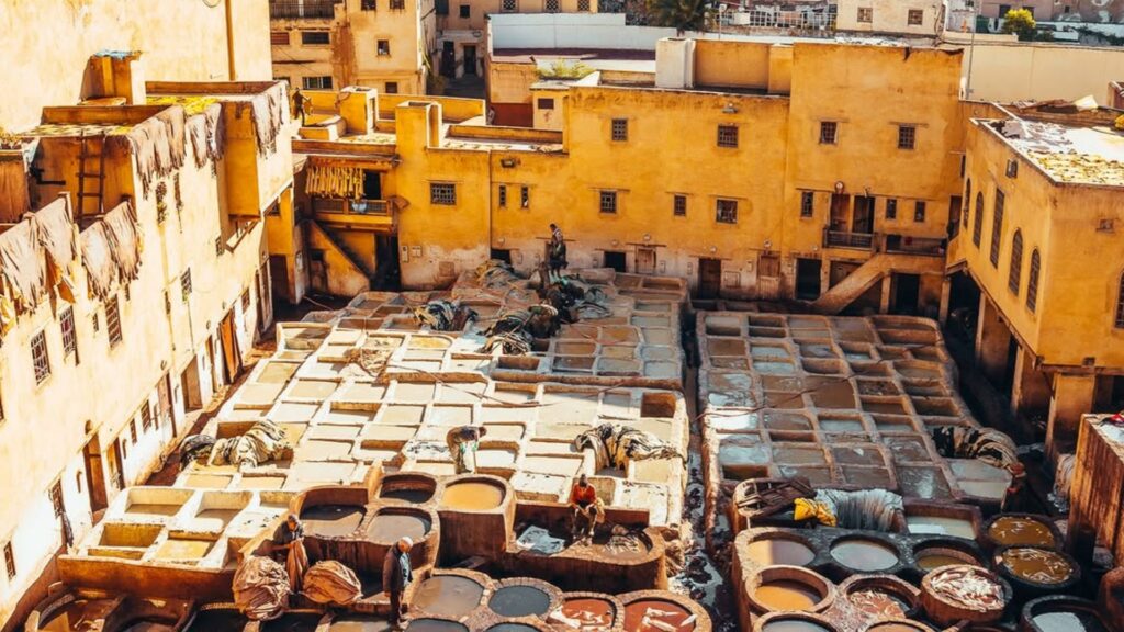 Vista de las curtidurías de Fez con los característicos cubos de colores y la medina al fondo. Reserva tu circuito por Marruecos con Haya Viajes.