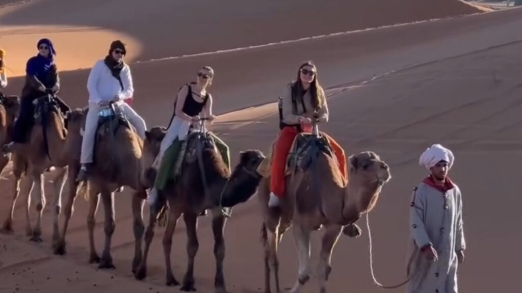 Paseo en camello por el desierto del Sahara Marruecos entre dunas doradas durante un tour al desierto